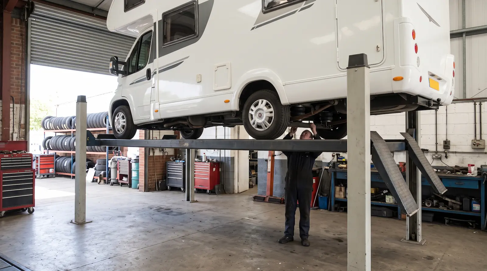 Motorhome on a four-post lift in the Motorhome Kings workshop having air suspension fitted
